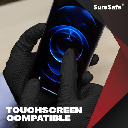 Person wearing 8 mil SureSafe IGRIP black gloves using a smartphone to show touchscreen sensitivity despite thickness.