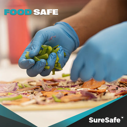 Person wearing blue SureSafe Hybrid Blend gloves while preparing a pizza to show food-safe compliance and visibility.