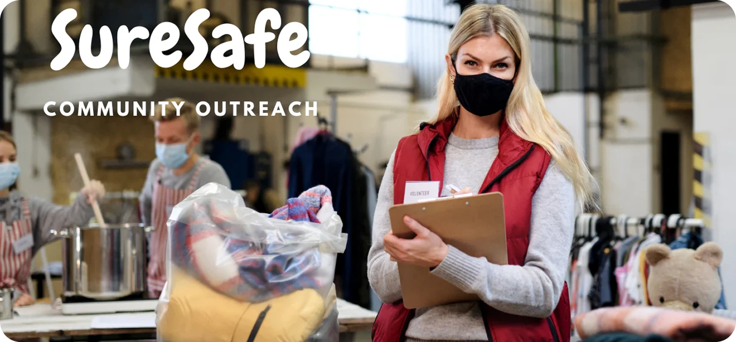 SureSafe Community Outreach banner featuring volunteers in face masks helping at a local clothing and food donation center.
