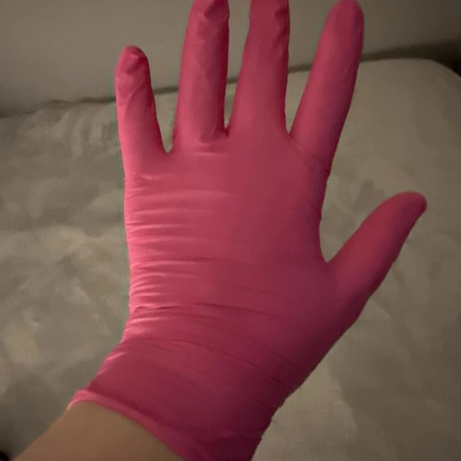 Professional wearing SureSafe Rose pink nitrile gloves showing a snug, soft, and comfortable fit for salon use.