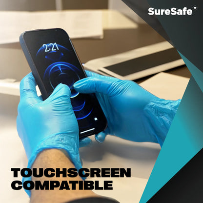 Person wearing blue SureSafe Hybrid Blend gloves using a smartphone to show touchscreen sensitivity for busy professionals.