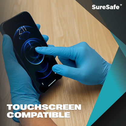 Person wearing blue SureSafe GLACIER nitrile gloves using a smartphone to show sensitivity and touchscreen compatibility.